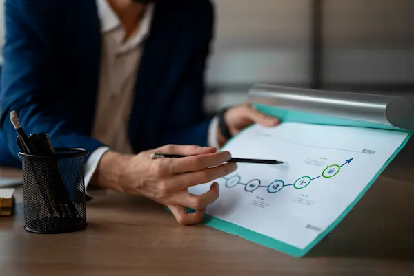 hombre señalando gráficos que indican el crecimiento del negocio tras aplicar la normativa ISO 31000
