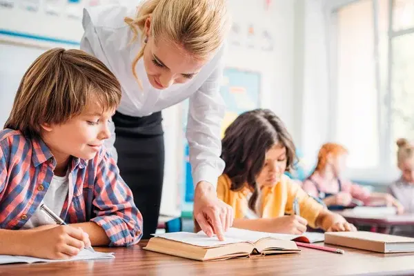 Niños siendo guiados por su maestra mientras estudian durante el día internacional de la educación