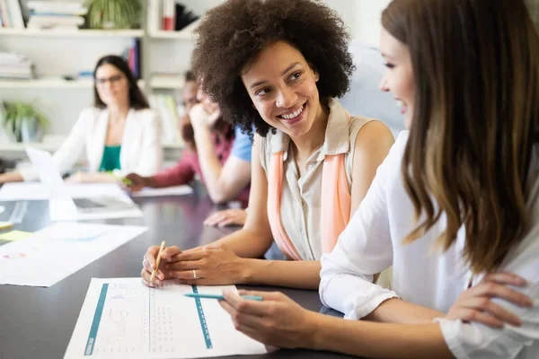 mujer sonriéndole a su compañera mientras realiza la evaluación de proveedores