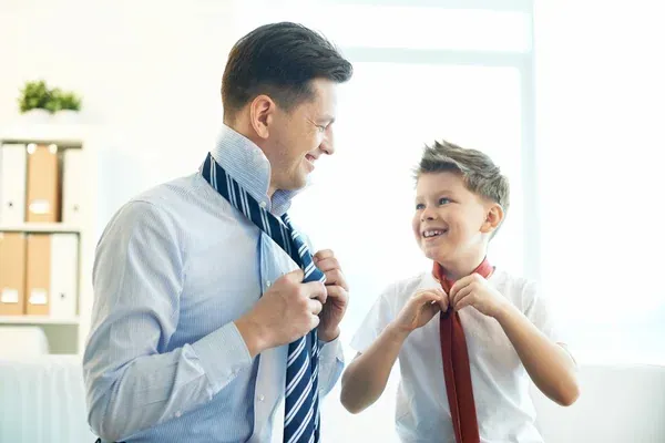 padre e hijo amarrándose la corbata juntos
